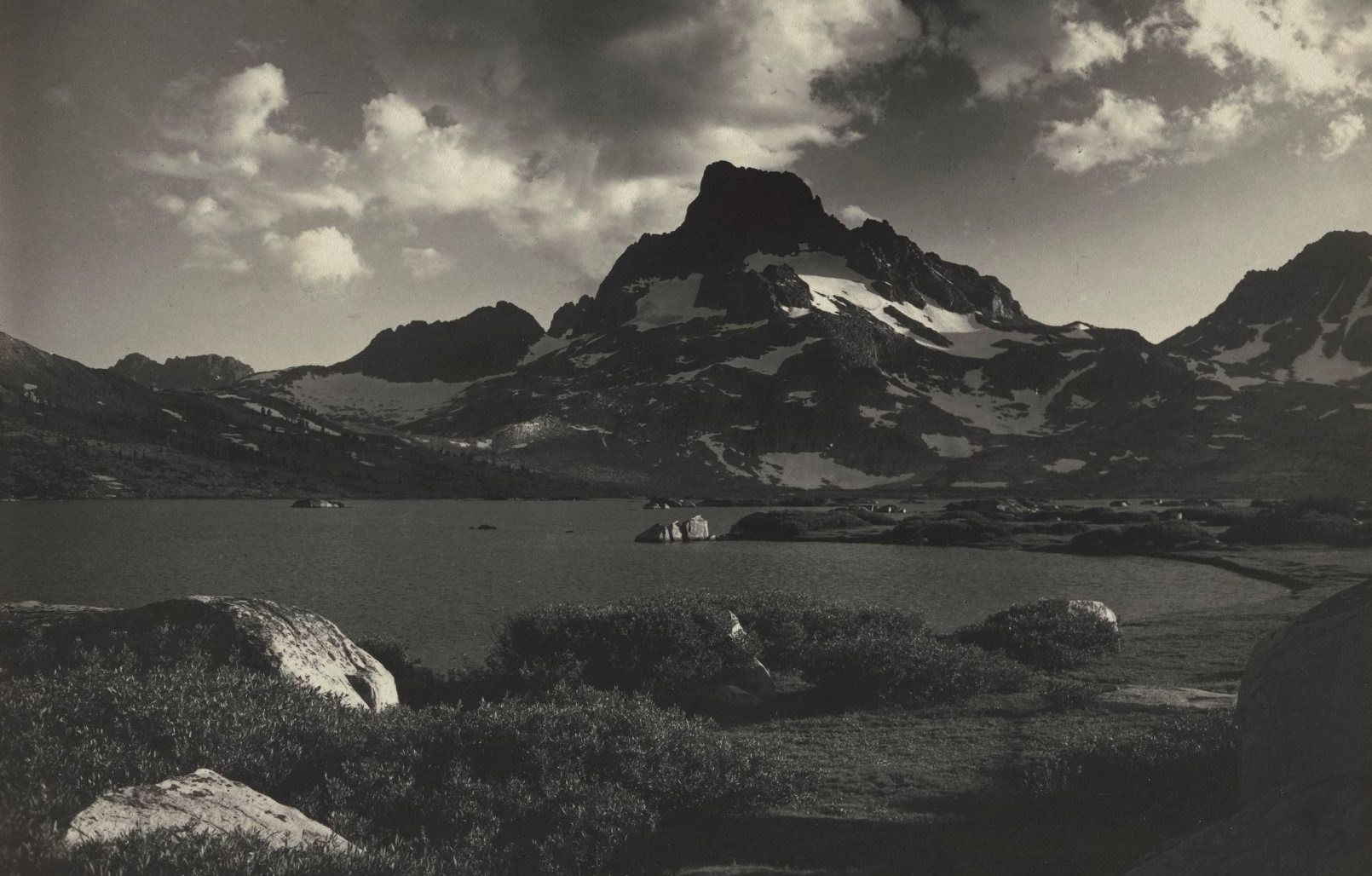 Black and white photo of a lake in front of a mountain