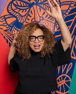 Ruth E. Carter standing in front of Brandon Sadler murals