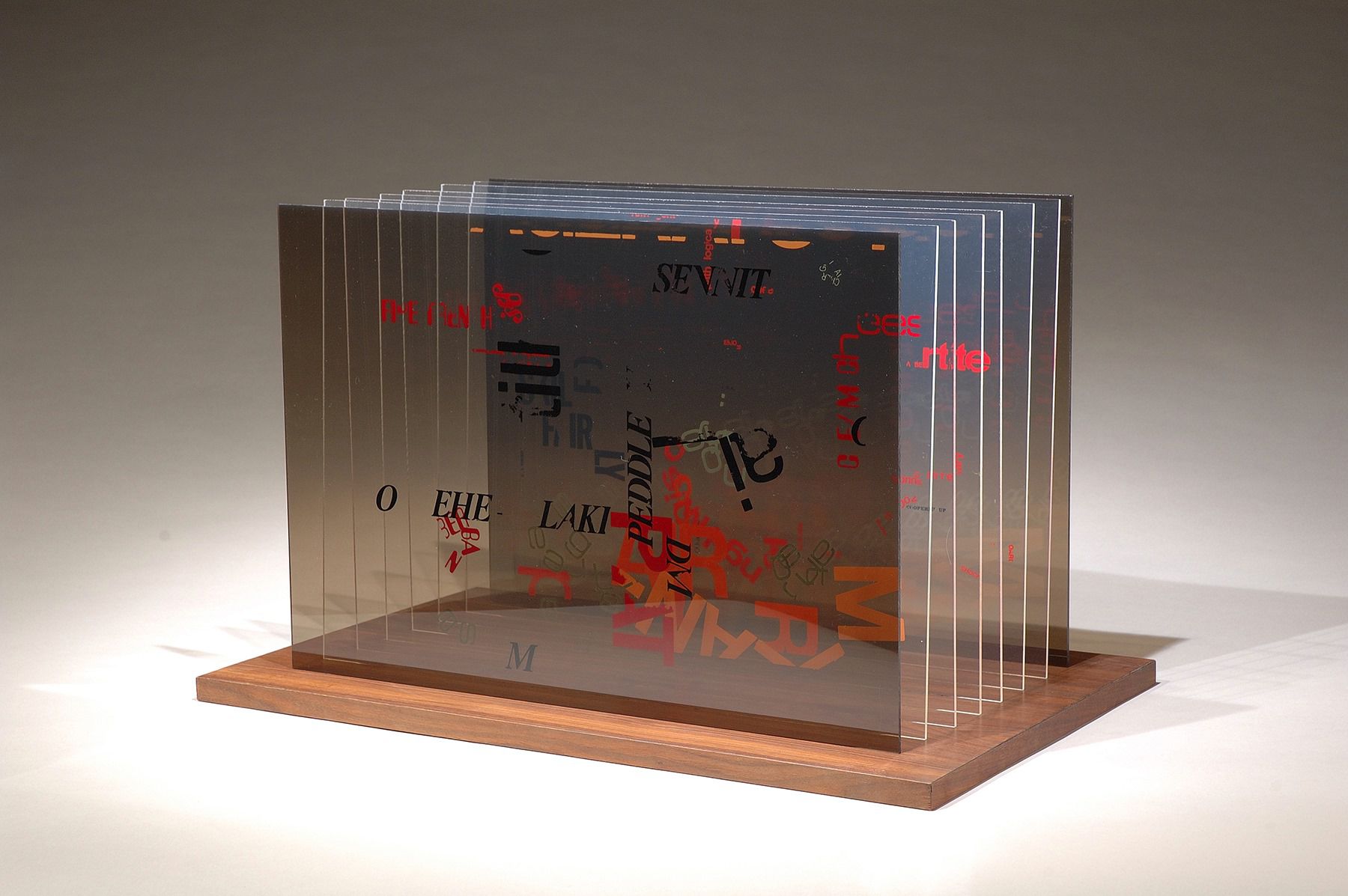 John Cage (American, 1912-1992), Not Wanting To Say Anything About Marcel Plexigram II, 1969; silkscreened Plexiglas mounted in walnut base, 14 1/2″ x 14 1/2″ x 14 1/2″, Purchased with funds from the Cherry Hill Endowment. 2006.005.001a‑i, .002 