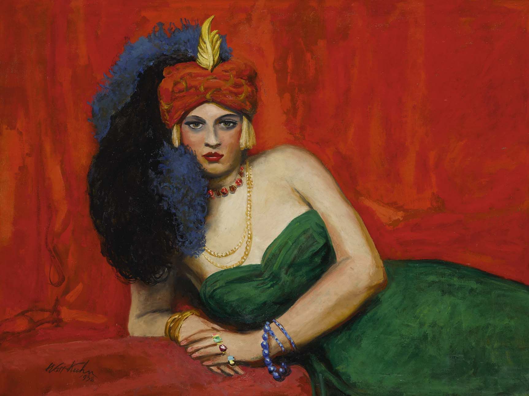 A woman wearing a green dress with a red headpiece that has a long blue and black feather tail