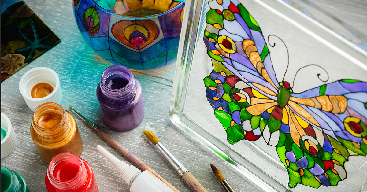 Artisan painting with stained glass paints on a glass