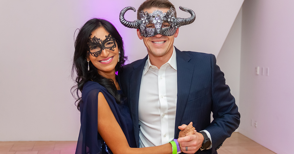 Two people wearing eye masks holding hands