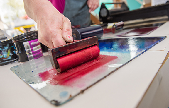 Person rolling ink on paper