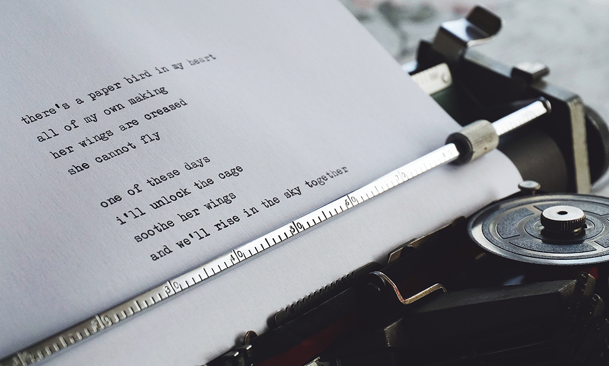 Typewriter with a white piece of paper that contains a typed poem
