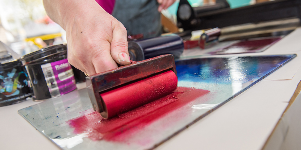 an acrylic paint roller for mono printing and screen printing, rolling paint ready for mono printing.