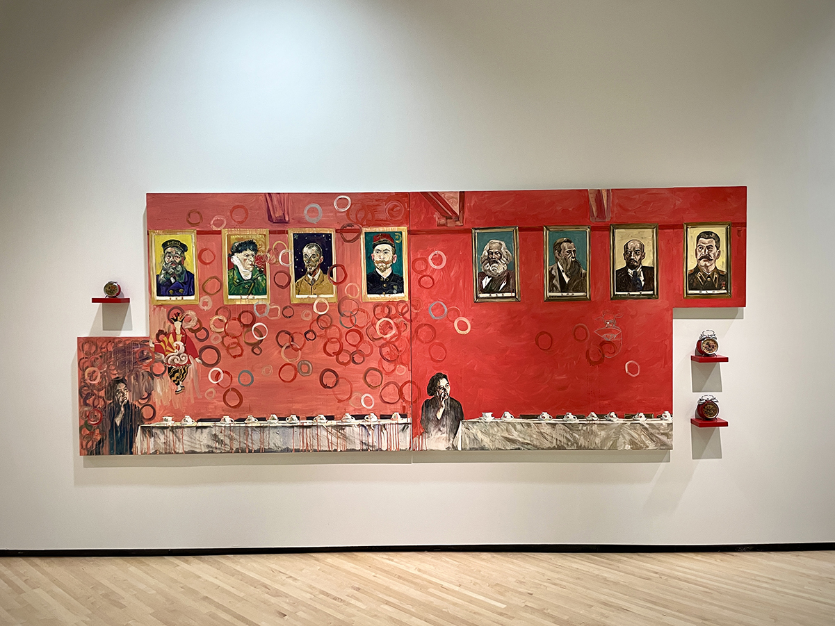 A large painting in a gallery with 8 portraits featuring artists and dictators with a woman appearing at the bottom of the painting looking up at the portraits