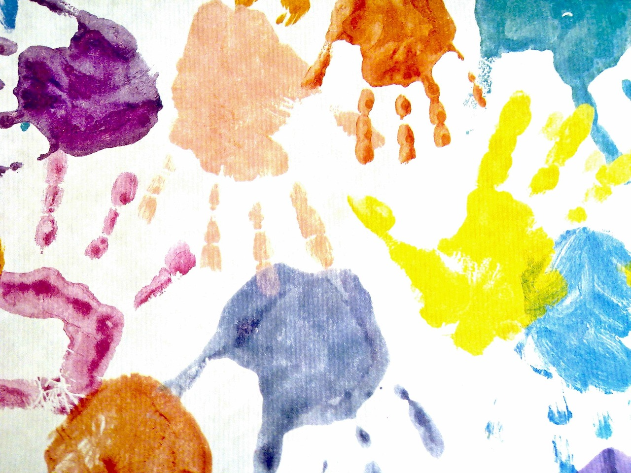 Collage of painted handprints in multiple colors
