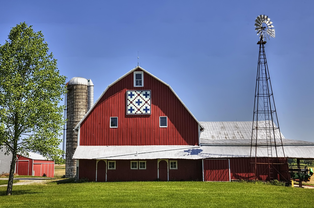 An image of a traditional red barn with a painted quilt square on the face of the barn.